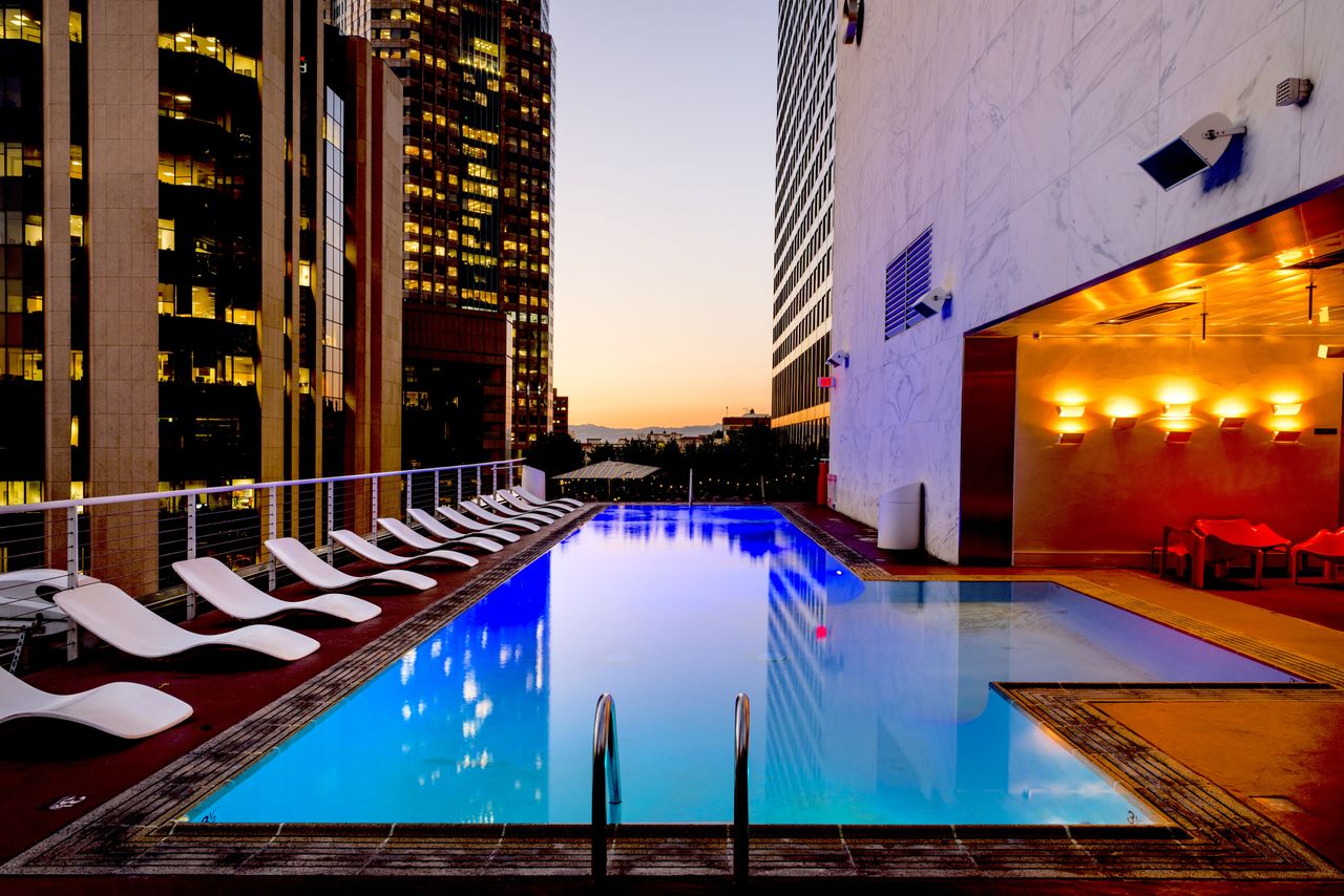 services-01 Elegant rooftop pool with cityscape backdrop at sunset, reflecting urban luxury.